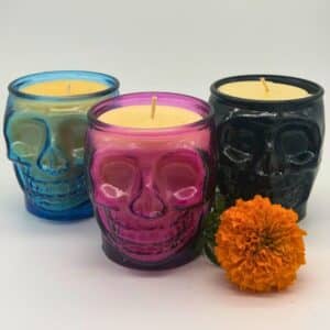 Dia de los Muertos skull candles in pink, blue, and black