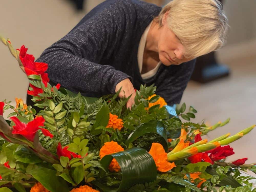 Lisa of Tabletop Alchemist putting the finishing touches on a custom flower arrangement